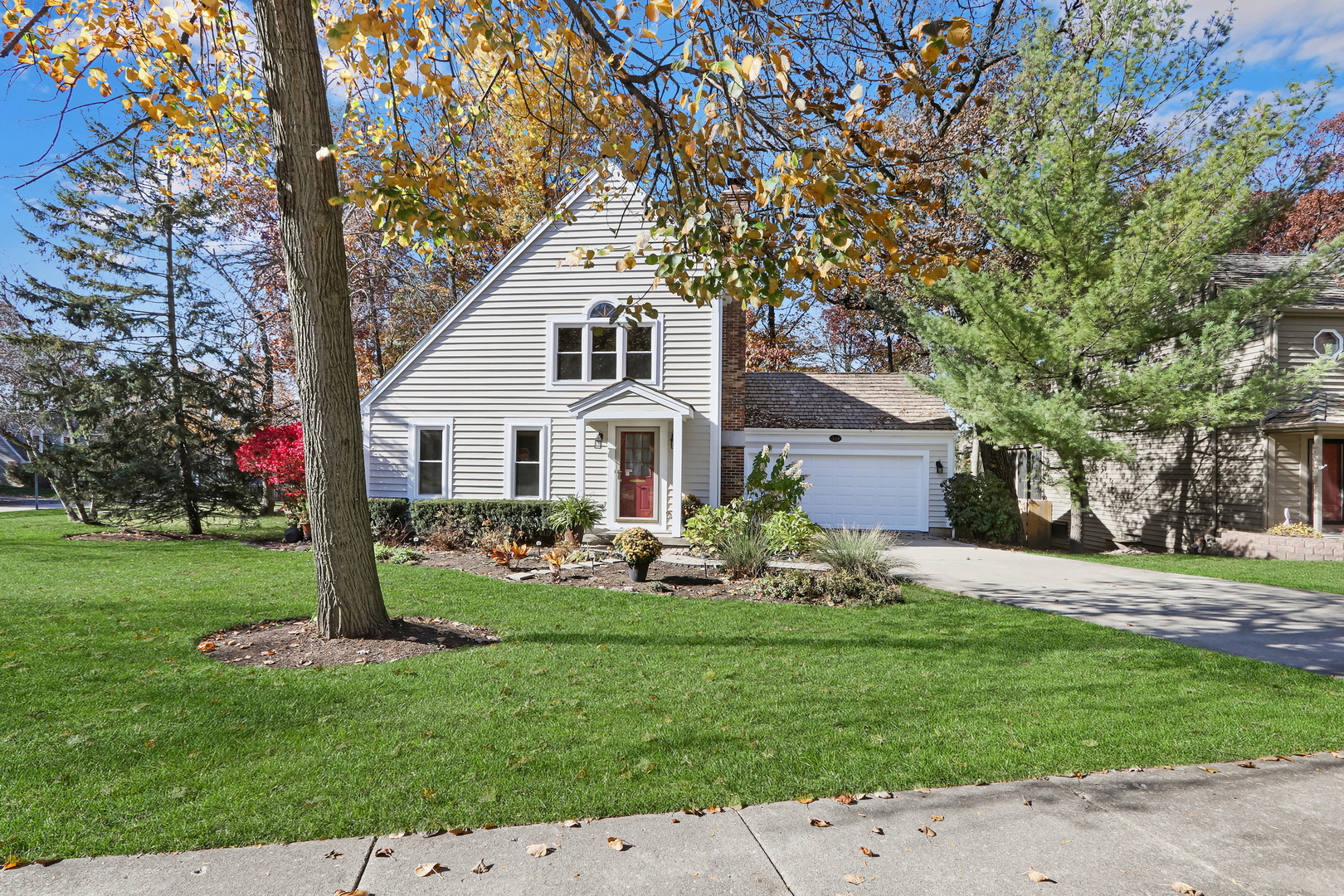 a front view of a house with a garden and trees