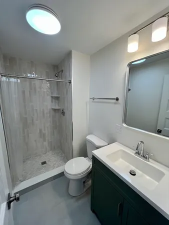 a bathroom with a sink mirror toilet and shower