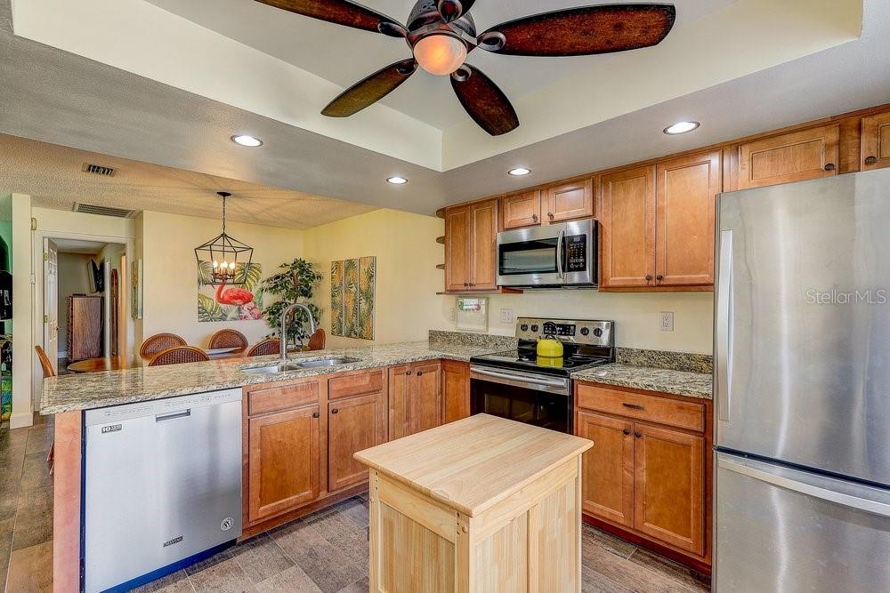 3454 Niblick Court New Port Richey, FL 34655 - Photo 12 of 54 a kitchen with stainless steel appliances granite countertop a refrigerator a stove a sink and a microwave