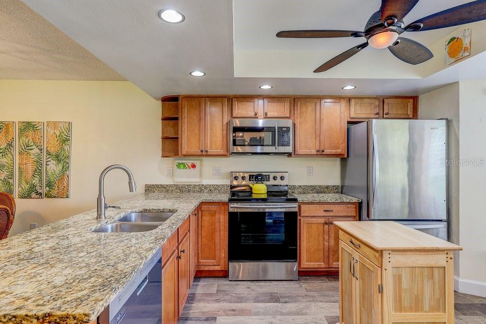 3454 Niblick Court New Port Richey, FL 34655 - Photo 10 of 54 a kitchen with stainless steel appliances granite countertop a sink stove and refrigerator