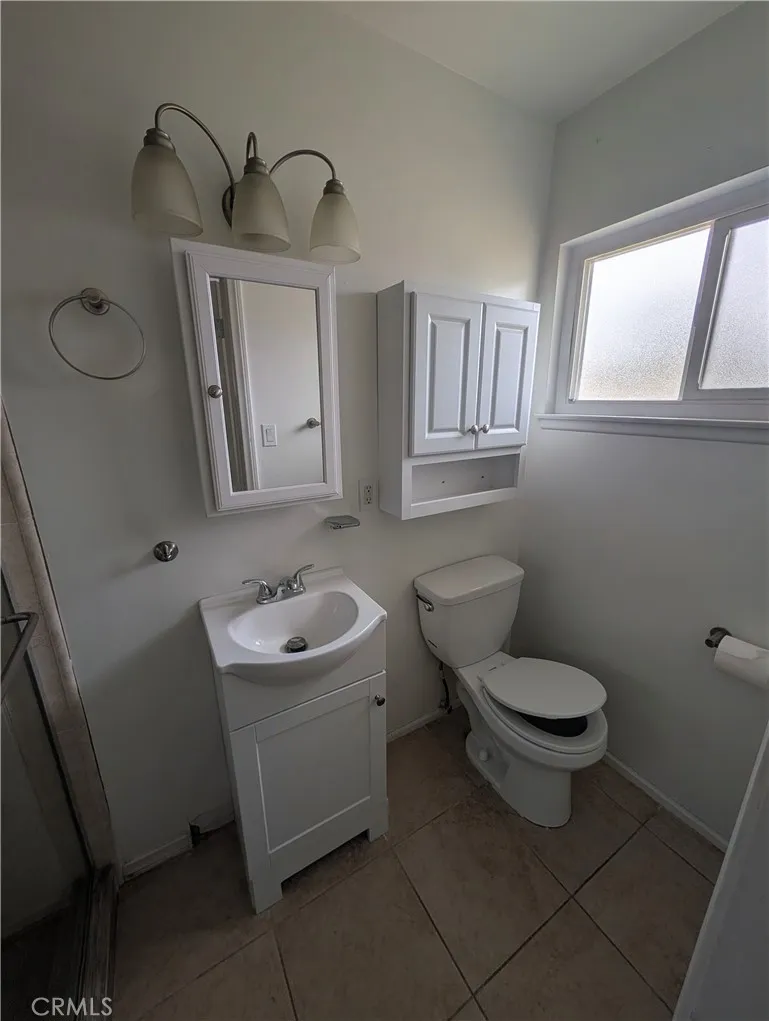 8641 Garfield Street, Unit 1 Riverside, CA 92504 - Photo 13 of 19 a bathroom with a toilet a sink and a window