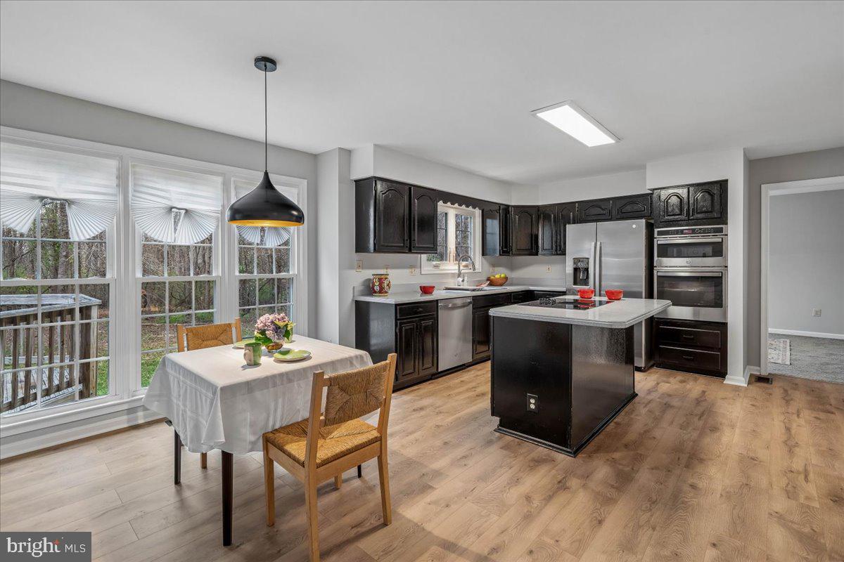 8010 Craddock Road Greenbelt, MD 20770 - Photo 18 of 49 a kitchen with kitchen island a sink and a stove top oven with wooden floor