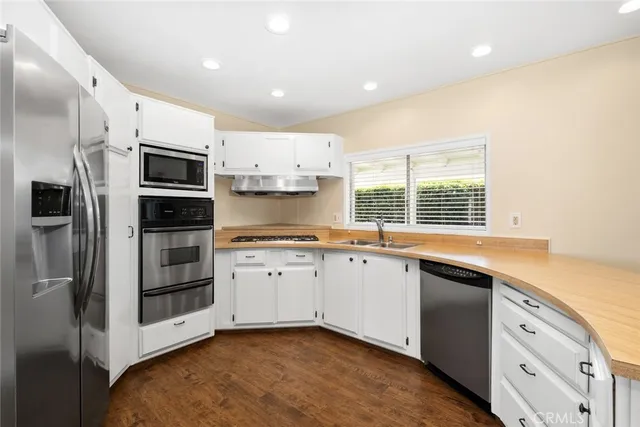 a kitchen with stainless steel appliances a sink stove and refrigerator