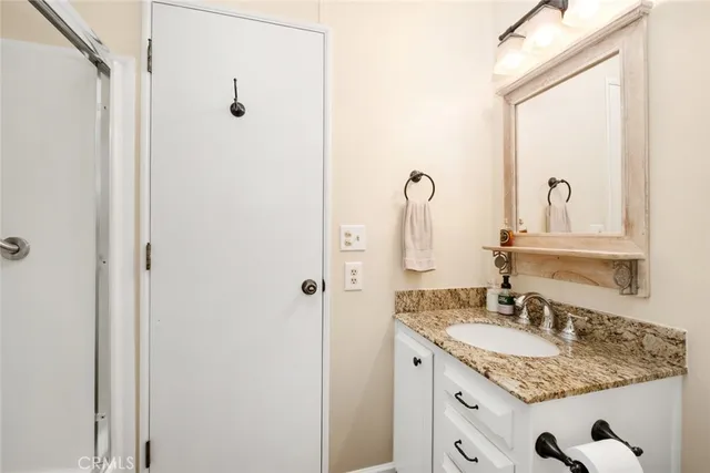 a bathroom with a granite countertop sink and a mirror
