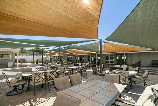 a view of a patio with table and chairs under an umbrella