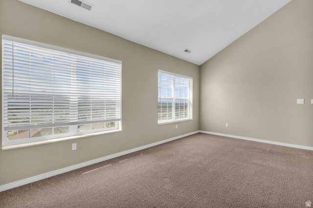 14108 Pepi Band Road Draper, UT 84020 - Photo 22 of 36 Spacious room featuring vaulted ceilings, light tan walls, and brown carpeting
