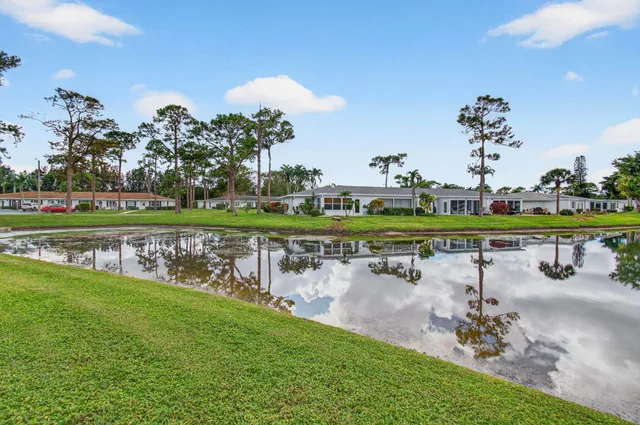 an aerial view of a house with a garden and lake view