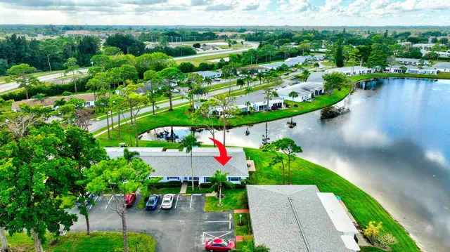 an aerial view of a house with a garden and lake view