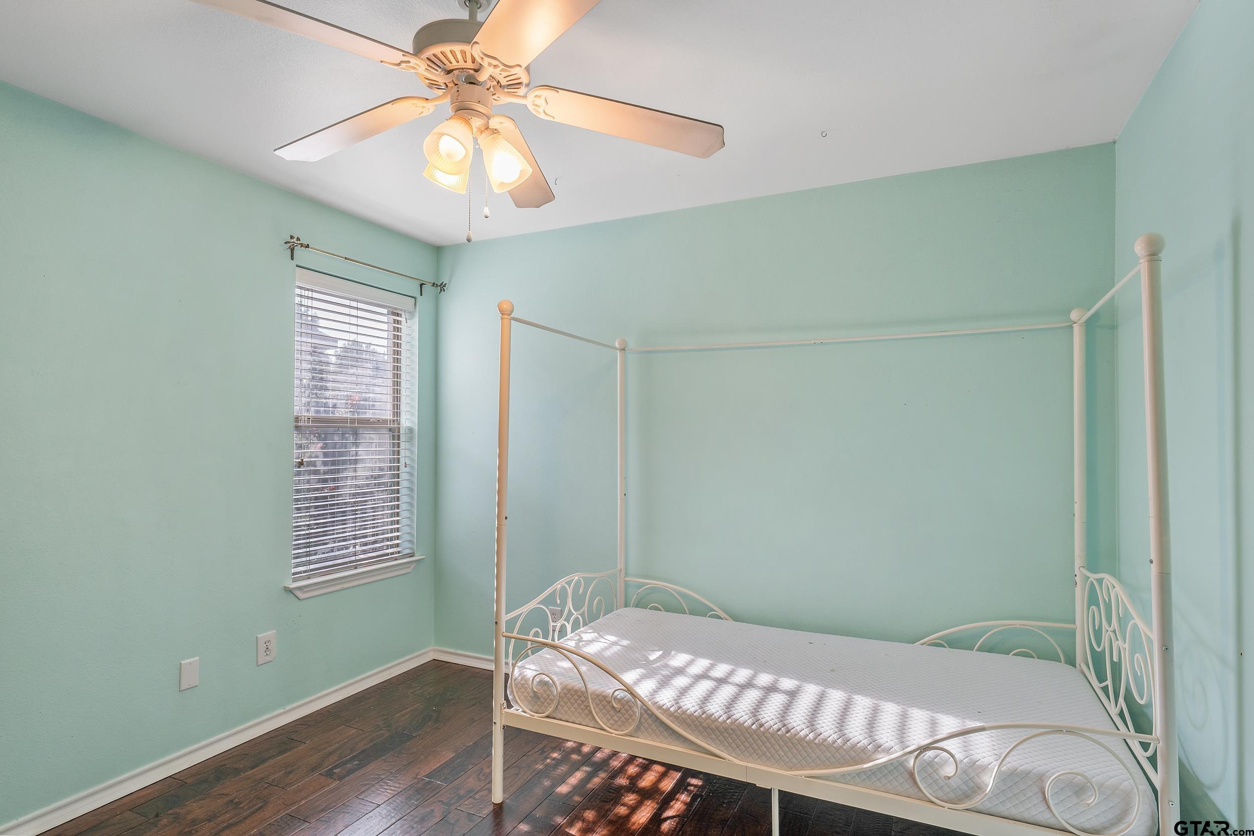 10820 Cactus Trail Flint, TX 75762 - Photo 21 of 29 a bedroom with a bed and a chandelier fan