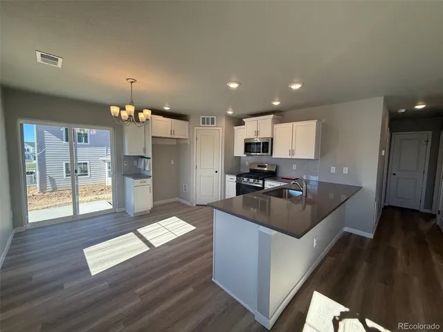 a kitchen with kitchen island granite countertop a sink counter top space and stainless steel appliances
