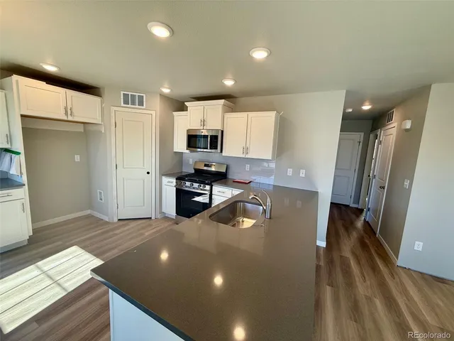 a kitchen with stainless steel appliances a refrigerator sink and microwave