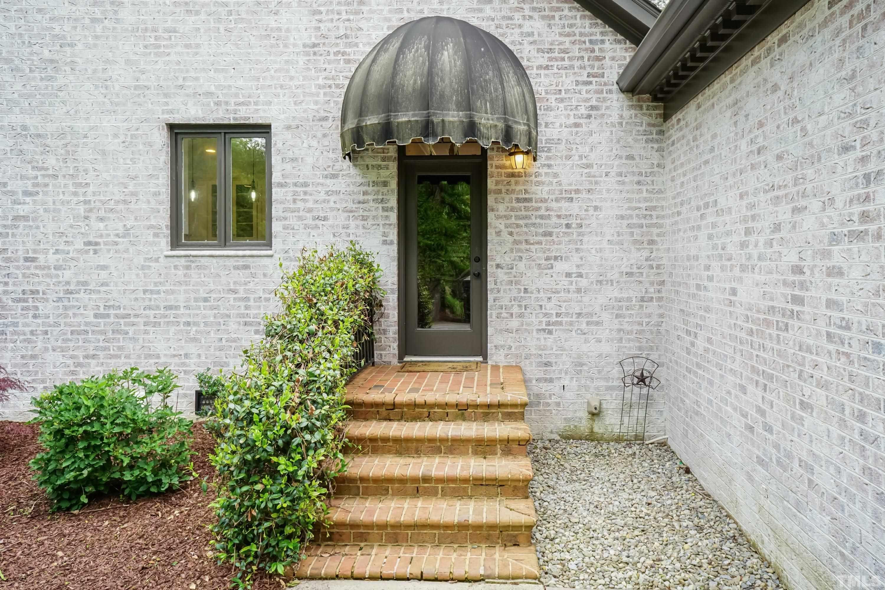 2215 Umstead Road Durham, NC 27712 - Photo 4 of 63 a front view of a house with plants