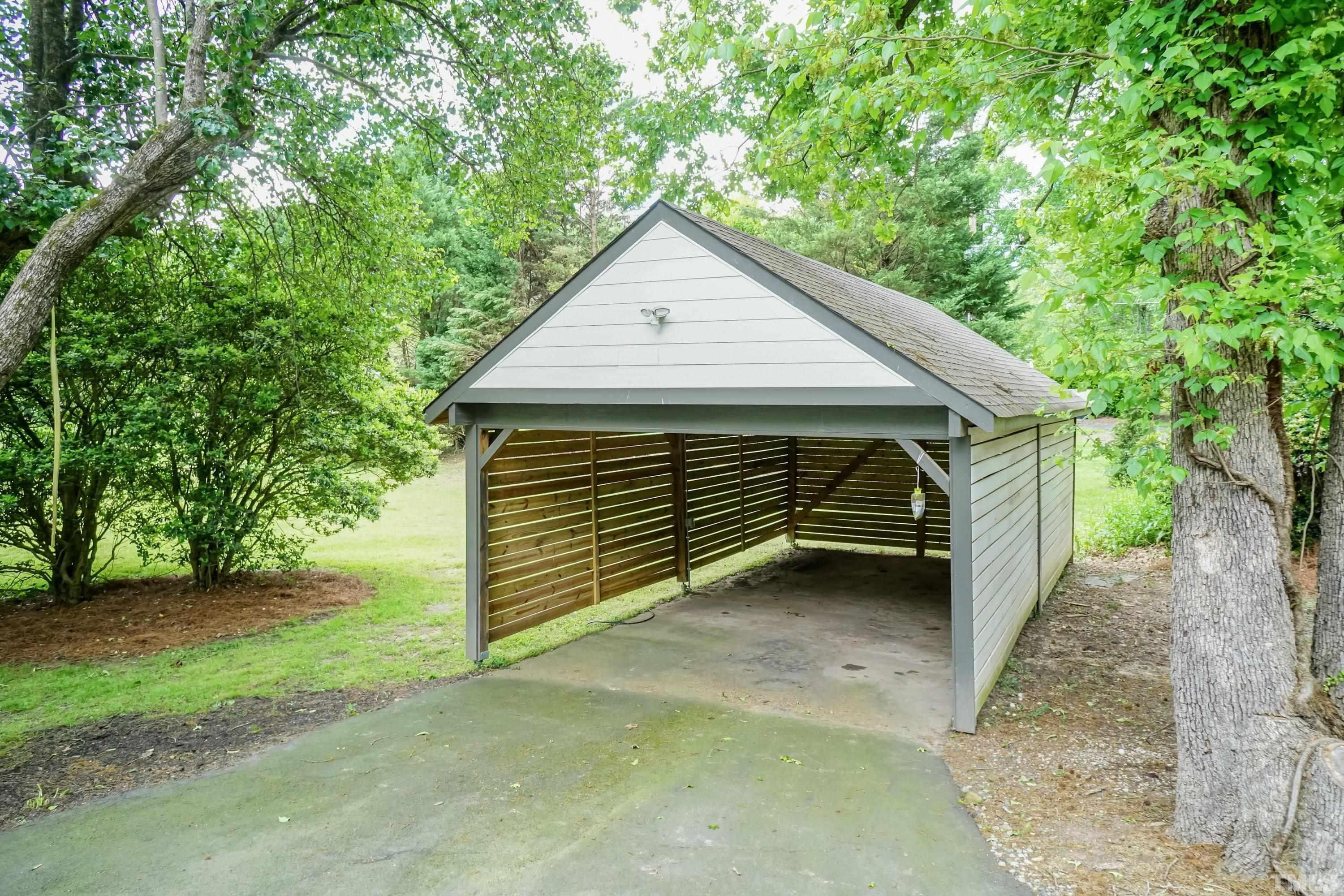 2215 Umstead Road Durham, NC 27712 - Photo 56 of 63 a view of backyard with a barn and a large tree