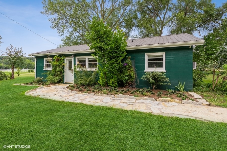 1S866 Green Road Elburn, IL 60119 - Photo 2 of 55 a view of a yard in front of a brick house with plants and large tree