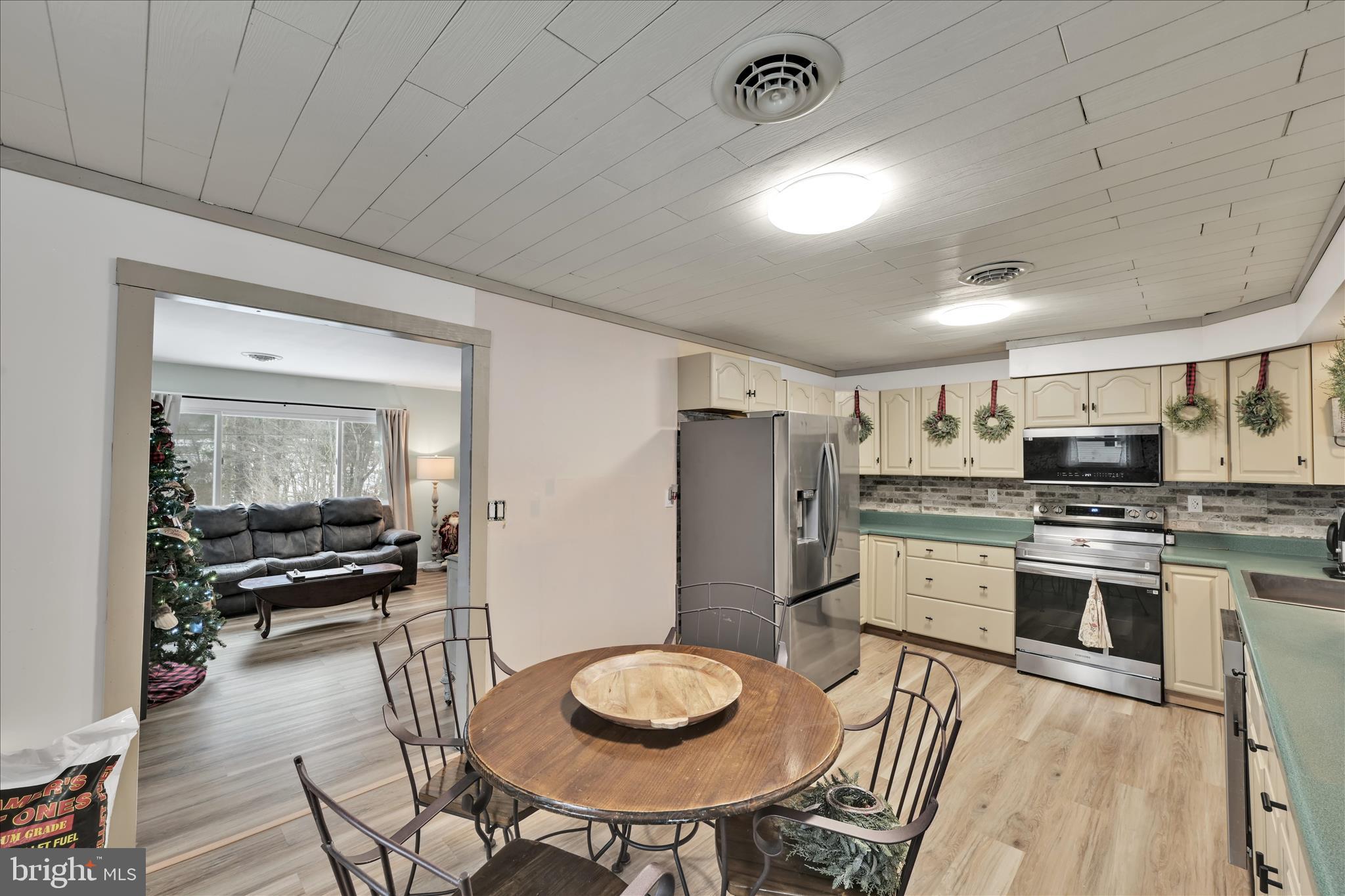 40 Long Stretch Road Pine Grove, PA 17963 - Photo 12 of 37 a kitchen with stainless steel appliances a dining table chairs stove refrigerator and cabinets