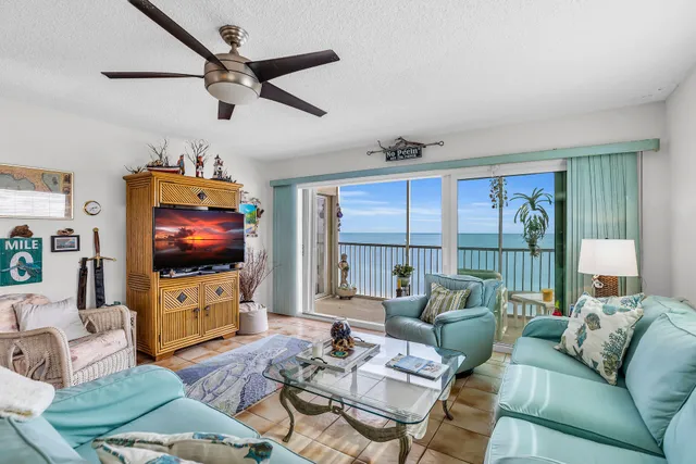 a living room with furniture a flat screen tv and a large window
