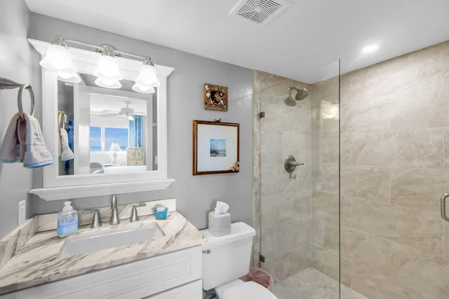 a bathroom with a granite countertop sink mirror and shower