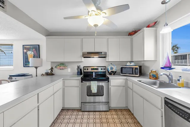 a kitchen with a sink cabinets stainless steel appliances and a window