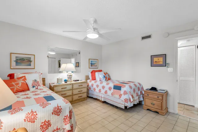 a bedroom with two beds and a chandelier