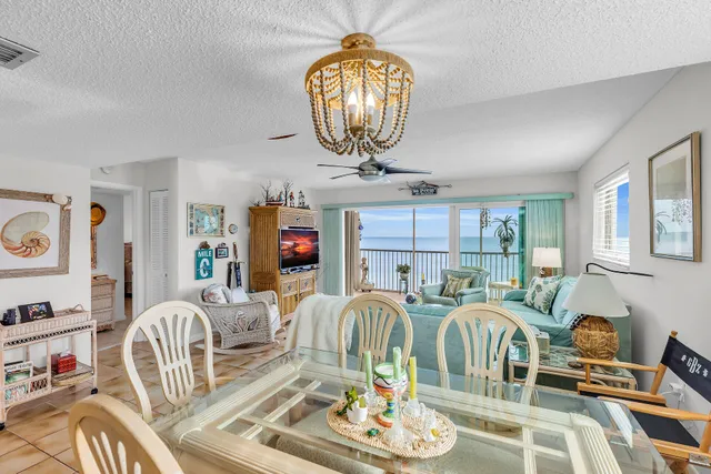 a living room with furniture a chandelier and a large mirror
