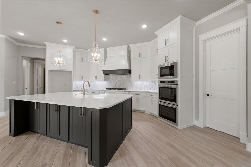 6610 Waggoner Way Midlothian, TX 76065 - Photo 14 of 40 Spacious kitchen featuring a large central island with dark cabinetry and a light countertop