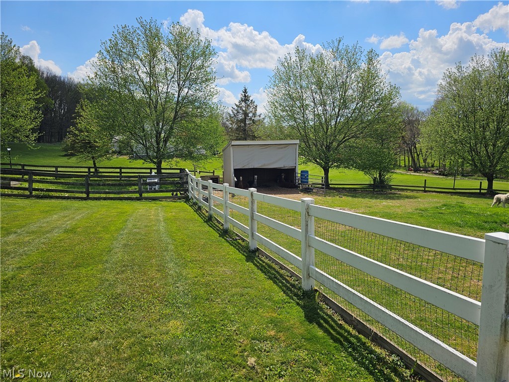 2363 Tabor Ridge Road Northeast New Philadelphia, OH 44663 - Photo 13 of 42 Expansive green lawn with a white three-rail fence and wire mesh