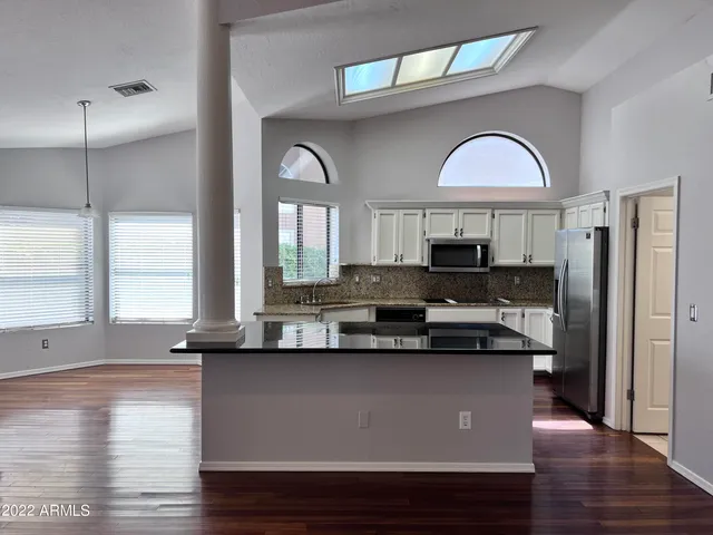 a kitchen with stainless steel appliances granite countertop a stove a sink and a refrigerator