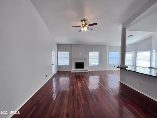 a view of empty room with wooden floor and fireplace