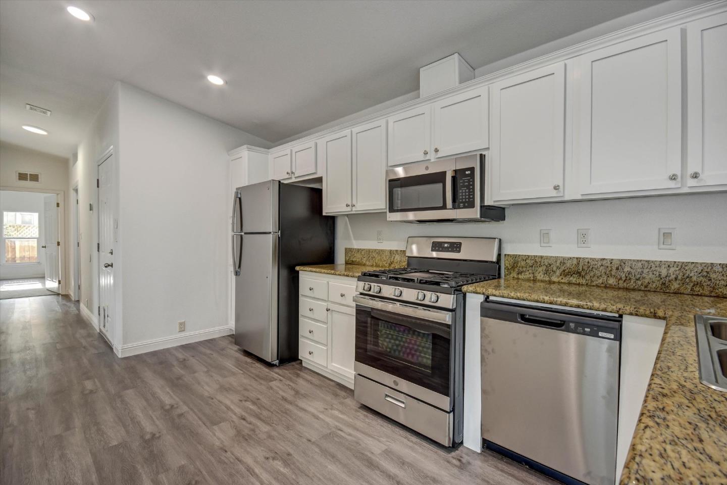60 Wilson Way, Unit 117 Milpitas, CA 95035 - Photo 20 of 29 a kitchen with stainless steel appliances granite countertop a stove a refrigerator and a microwave