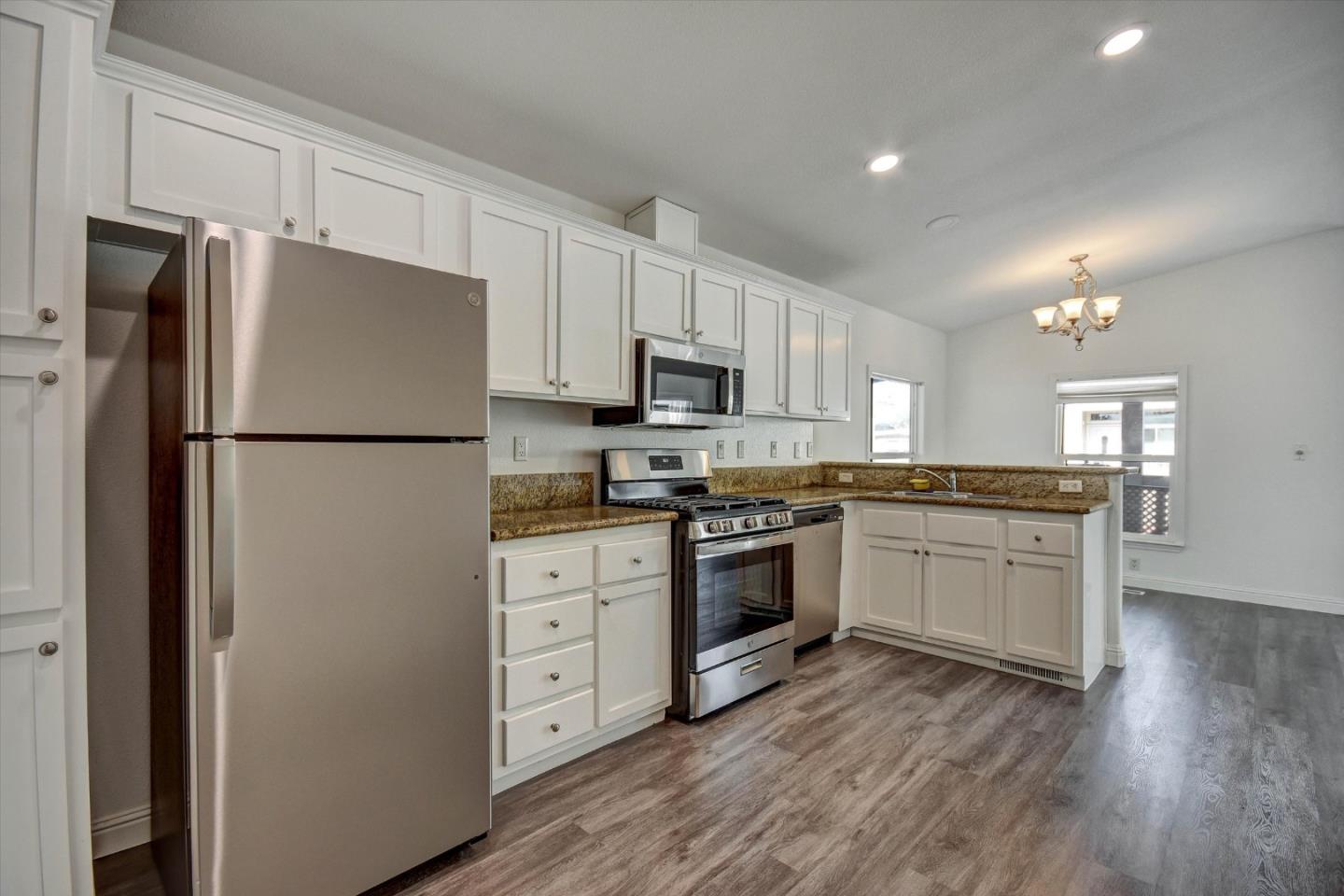 60 Wilson Way, Unit 117 Milpitas, CA 95035 - Photo 21 of 29 a kitchen with granite countertop a refrigerator stove top oven and sink