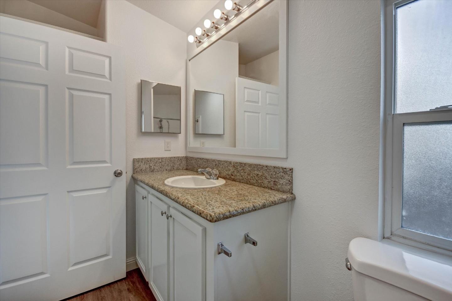 60 Wilson Way, Unit 117 Milpitas, CA 95035 - Photo 7 of 29 a bathroom with a granite countertop sink and a mirror