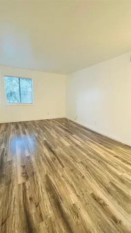 a view of empty room with wooden floor