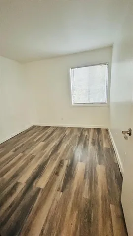 a view of a room with wooden floor and a window
