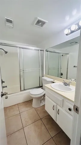 a bathroom with a granite countertop sink a toilet and a shower