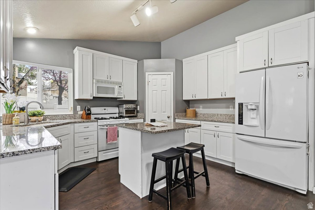 7975 Showcase Lane Sandy, UT 84094 - Photo 6 of 29 Shaker kitchen with beautiful white appliances and sit-up island