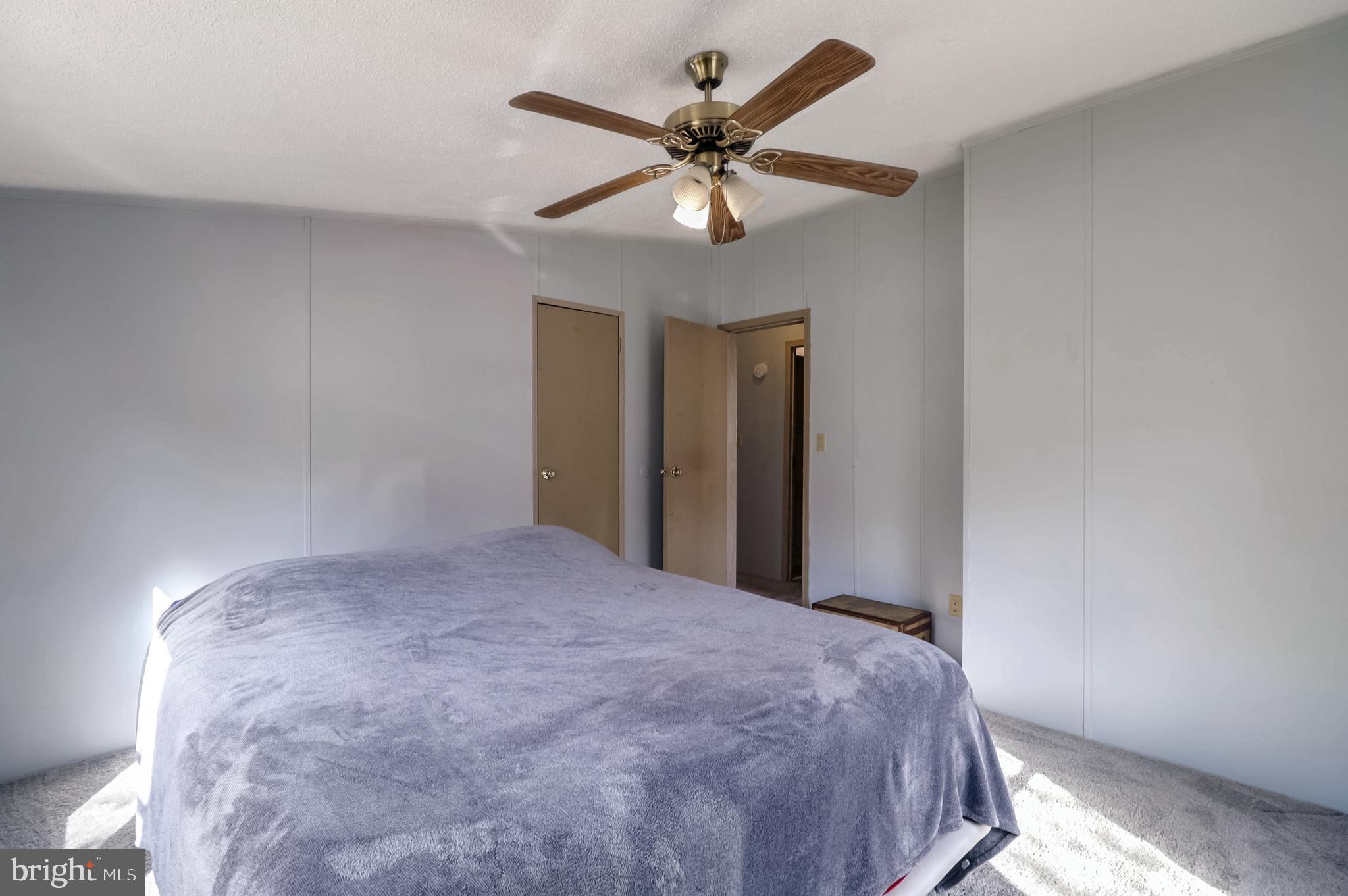 7810 Clark Road, Unit E15 Hanover, MD 21076 - Photo 12 of 20 a bedroom with a large bed and a ceiling fan