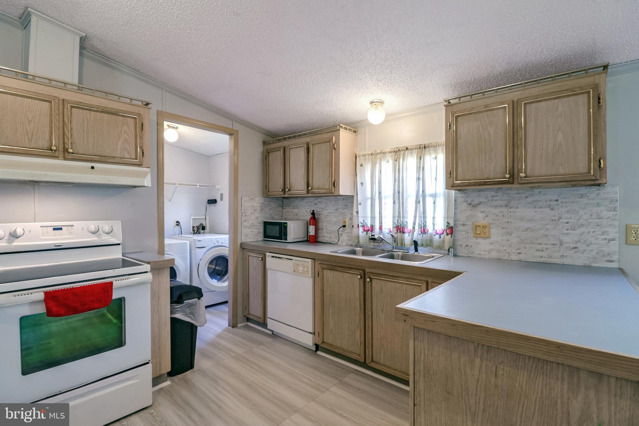 7810 Clark Road, Unit E15 Hanover, MD 21076 - Photo 7 of 20 a kitchen with a stove a sink and a refrigerator