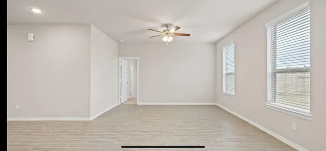 a view of a livingroom with a ceiling fan and window