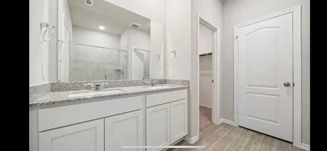 a bathroom with a granite countertop sink and a mirror