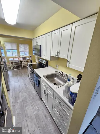 a kitchen with granite countertop a refrigerator a stove and a sink