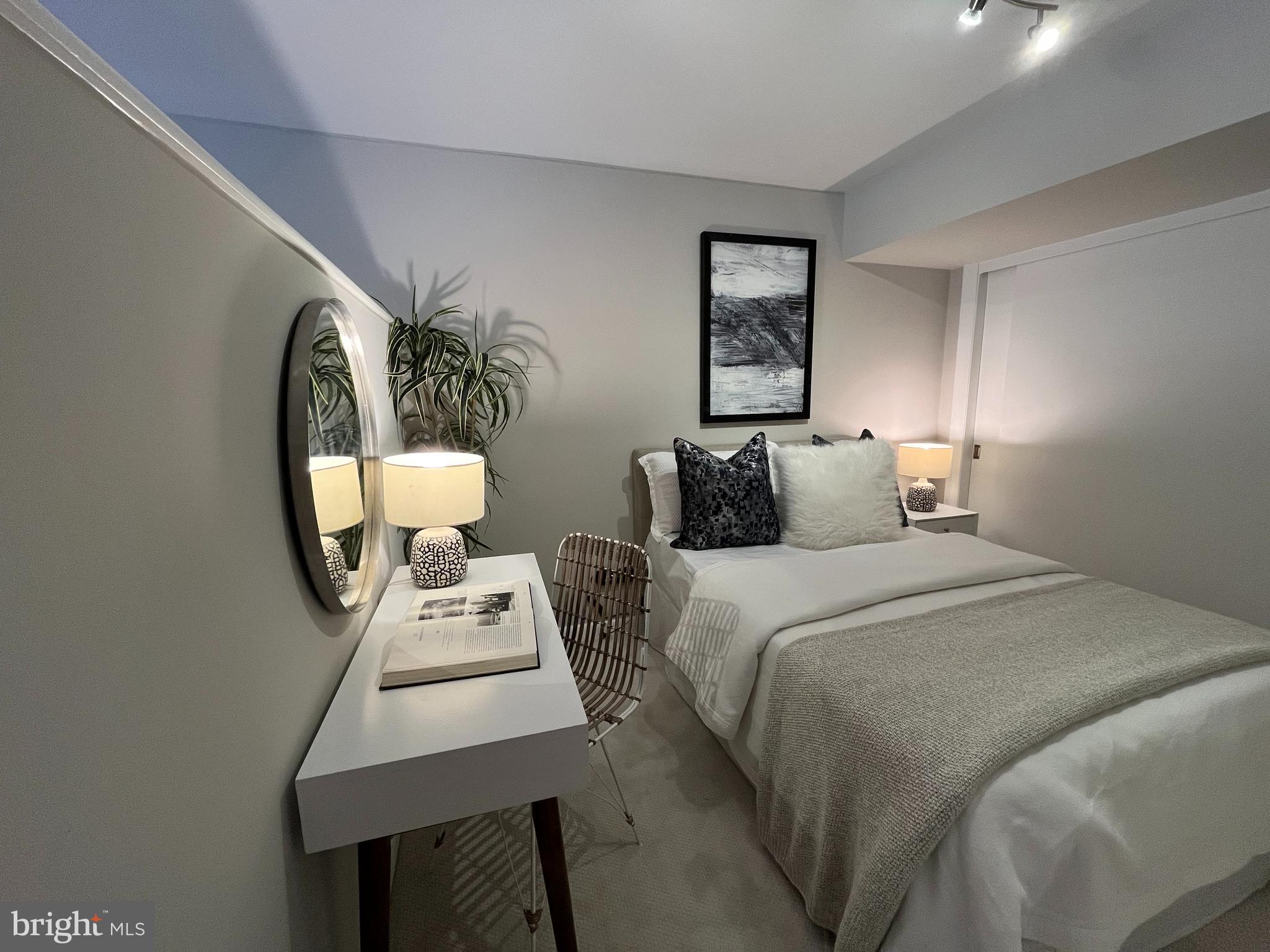 811 4th Street Northwest, Unit 112 Washington, DC 20001 - Photo 15 of 44 a bedroom with a bed a mirror and wall painting