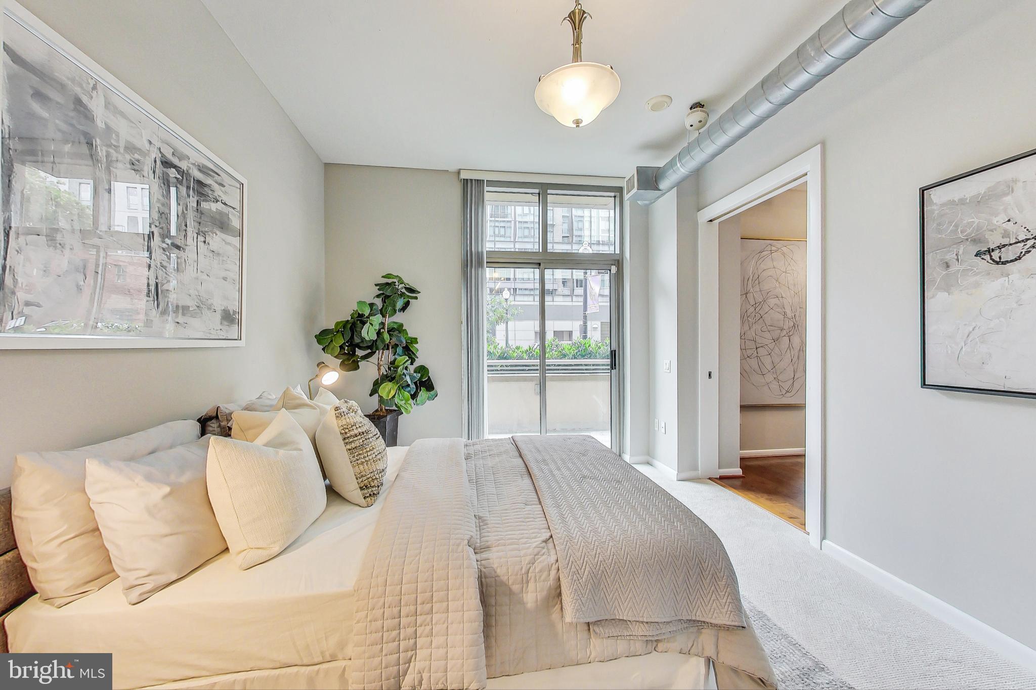 811 4th Street Northwest, Unit 112 Washington, DC 20001 - Photo 9 of 44 a bedroom with a large bed and a chandelier