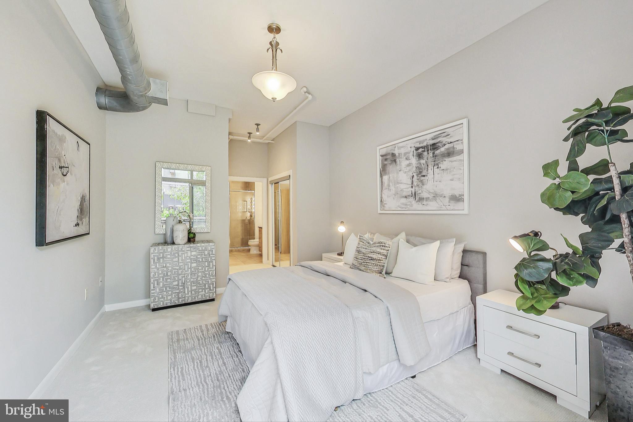 811 4th Street Northwest, Unit 112 Washington, DC 20001 - Photo 10 of 44 a bedroom with a large bed and a chandelier