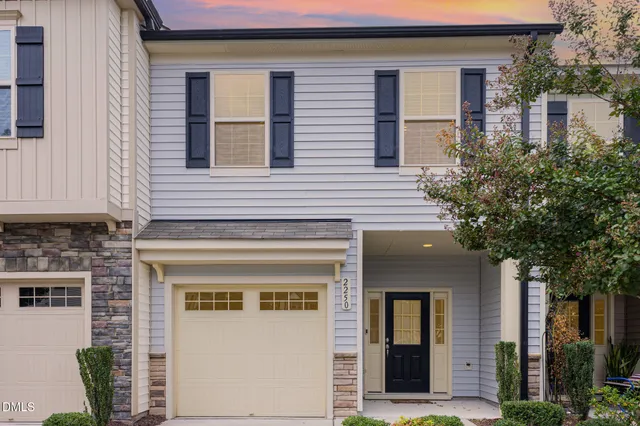 a view of a white house with large windows and a tree
