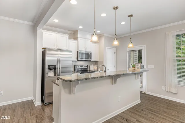 a kitchen with stainless steel appliances a refrigerator a sink and a stove