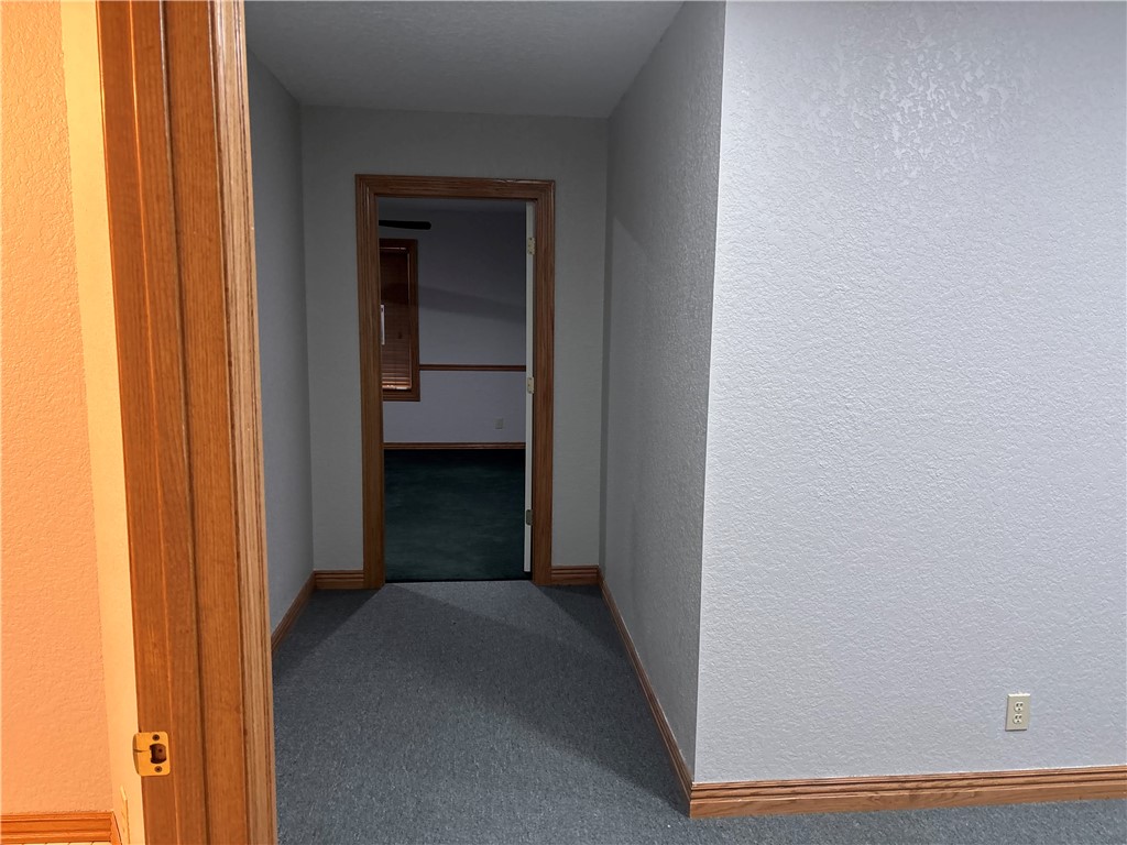 15262 Shipe Road Gravette, AR 72736 - Photo 8 of 60 Textured wall finish, wood trim, and carpeted flooring