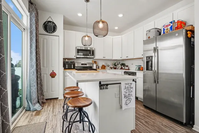 a kitchen with stainless steel appliances granite countertop a refrigerator a sink and a stove