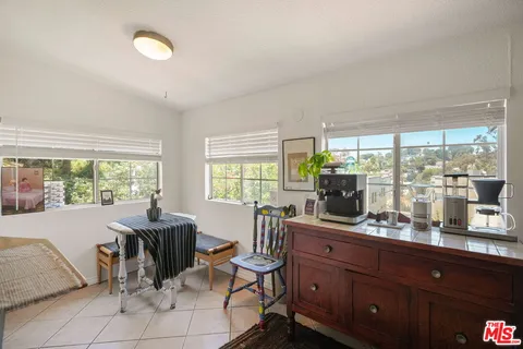 a room with a large window and dining table chair