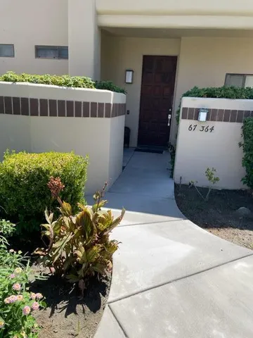 a view of a house with a yard and a bench in it