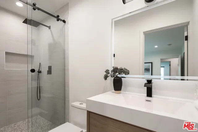 a bathroom with a sink mirror and shower